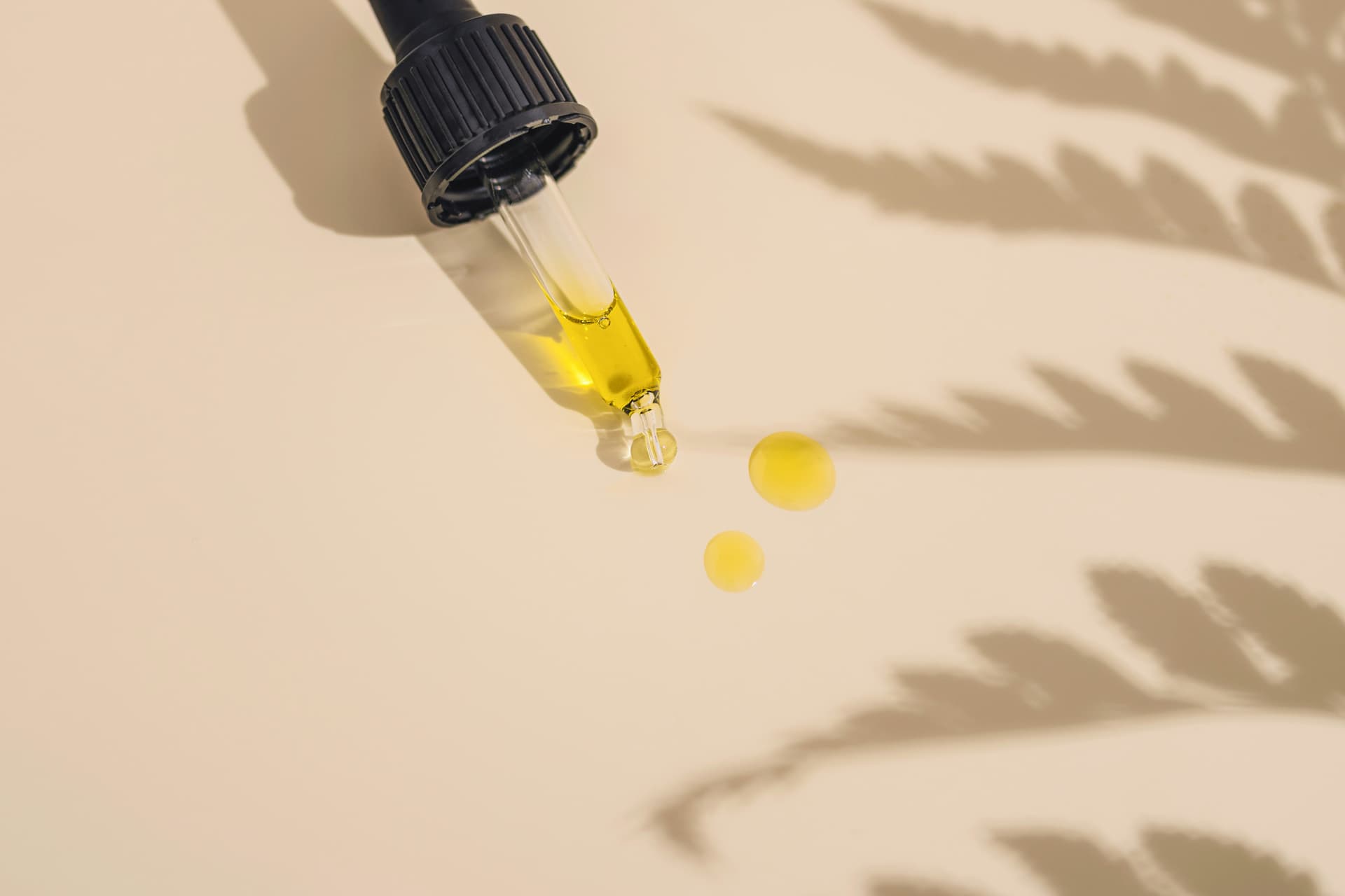 Golden skincare serum being dispensed from dropper bottle